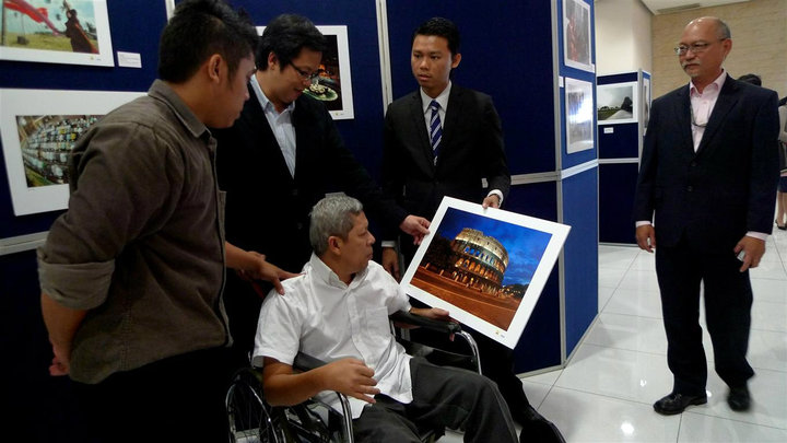 King Chai showing off one of Uncle Hatim's works from his days as a Petronas photograppher to Senator Gan