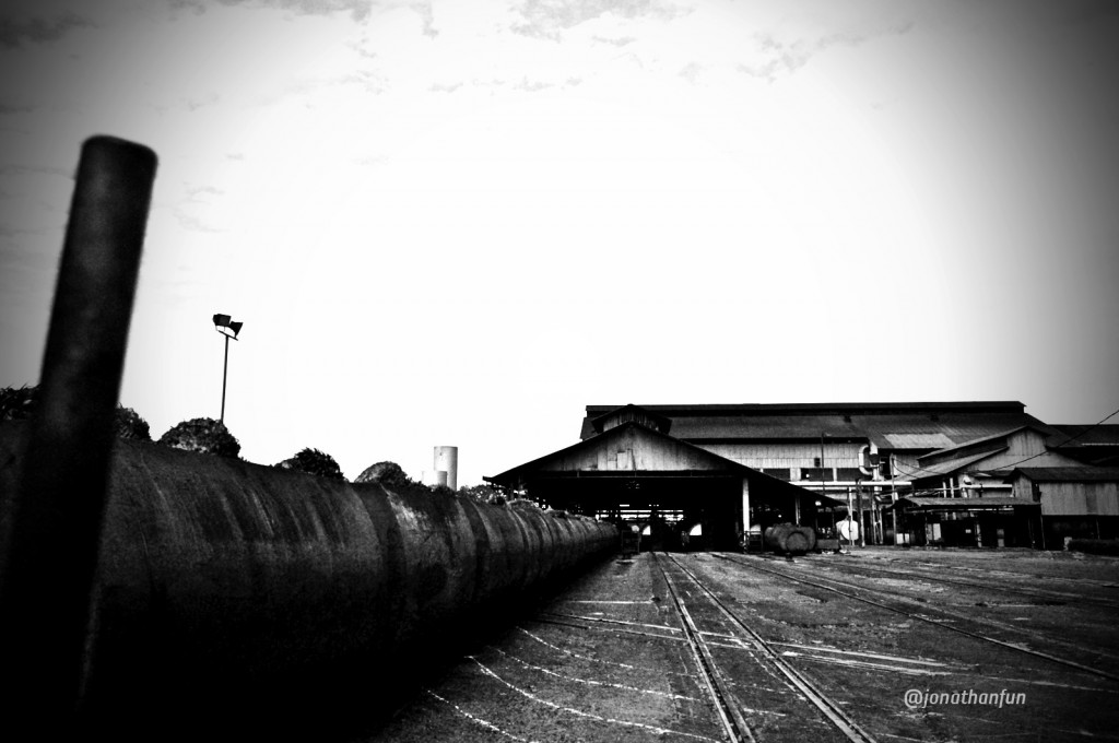 The view from the Marshaling Yard towards the Main Process Building. Fresh Fruit Bunches are fed into steel cages like those on the left, and marshaled into the Sterilizer Machines for cooking.