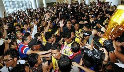Malaysian players are mobbed by hundreds of fans upon arrival at KLIA -- Source: The Star
