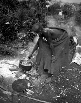 A woman cooking lunch in a pot of murky water