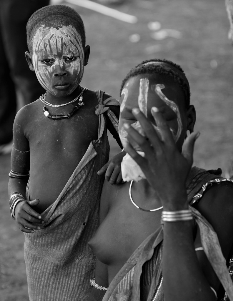 A young Mursi boy resting his hand on his much older sister. A picture of sibling protection or gender subjugation?